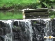 Sexy babe pees near a waterfall 1/16